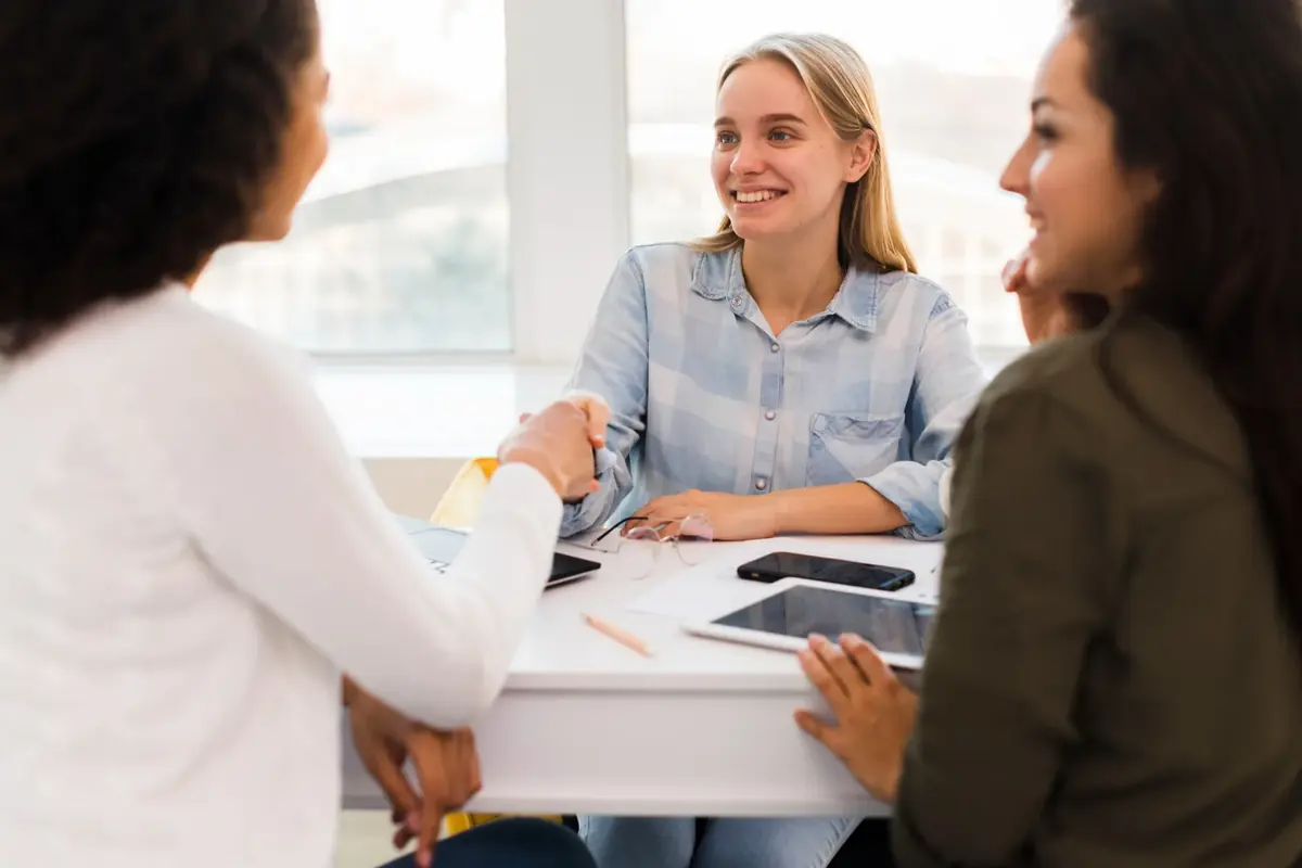 Drie collega's bespreken samen een verandering aan tafel